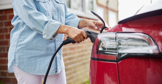 woman plugging an EV charger into the car